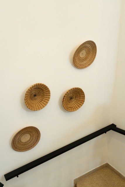 Handwoven baskets displayed on the stairwell wall